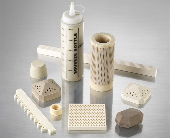 Custom refractory and specialty shapes Custom refractory and specialty ceramic shapes, including formed bars, a perforated cylinder, and faceted blocks.